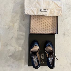 Navy blue satin peep toe pumps with metallic trim.